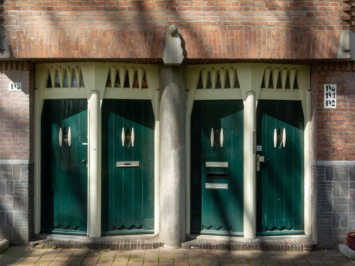 Groene voordeuren in Amsterdamse School-stijl